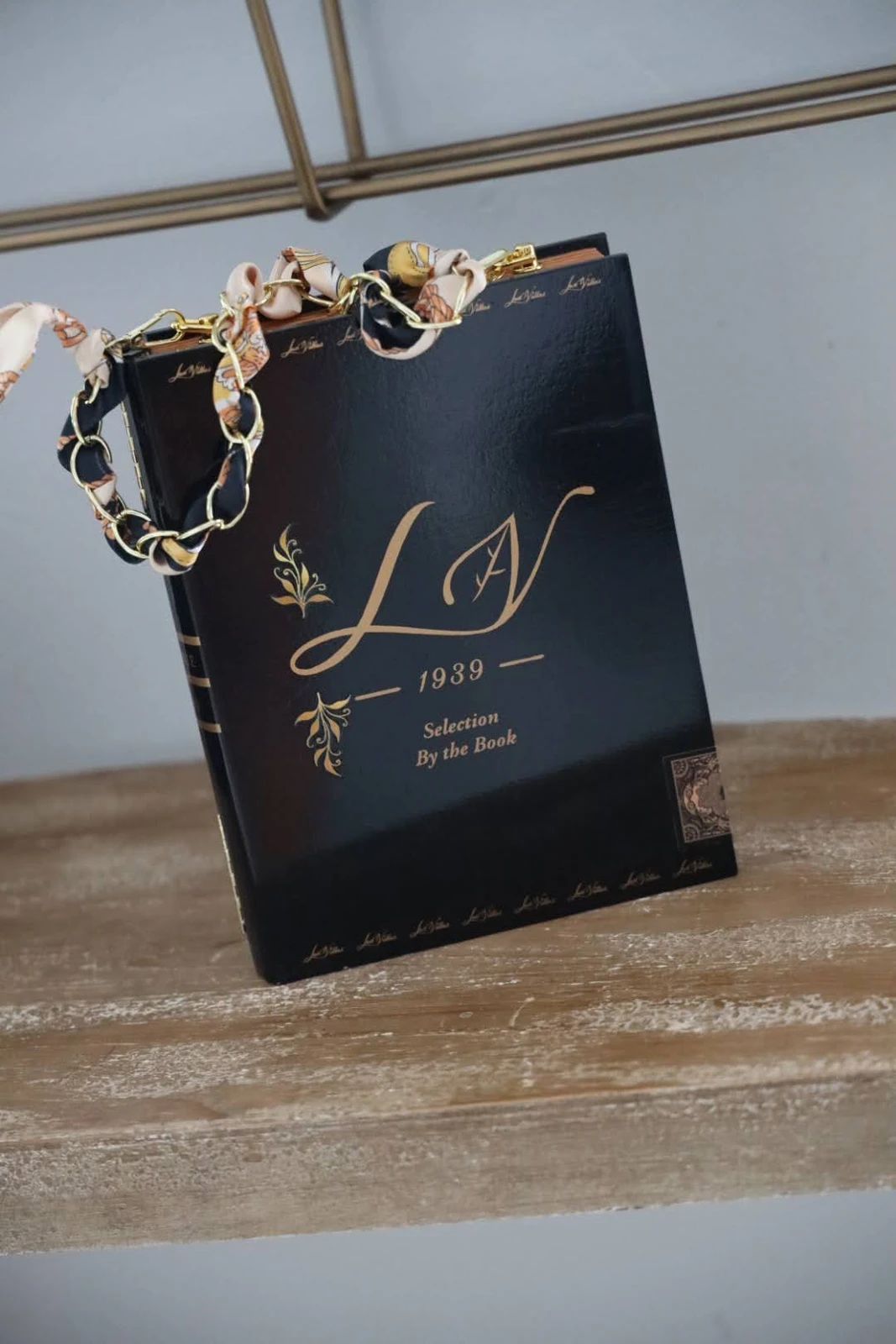 Black cigar-box handbag with gold-toned details and chain-style handle