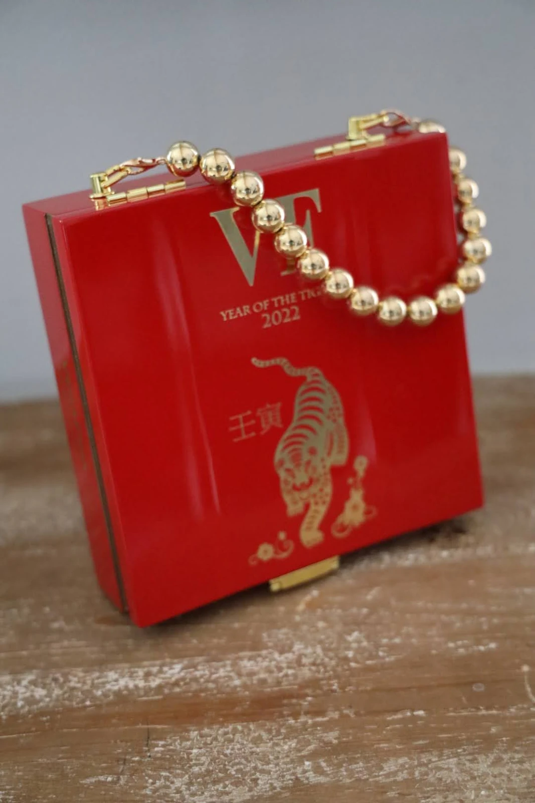 Red cigar-box handbag with golden decorative beaded handle